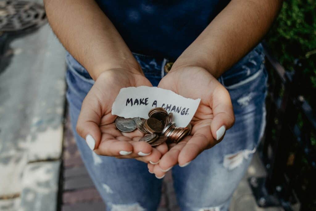 Step-by-Step Guide To Organizing Cancer Fundraising Events 36 person showing both hands with make a change note and coins
